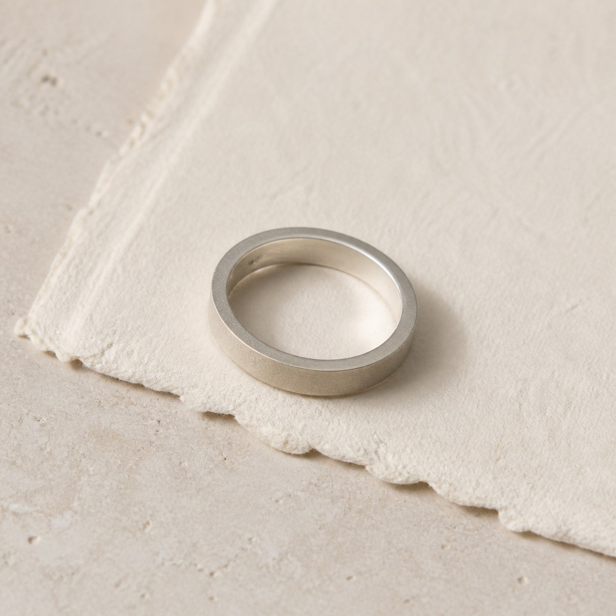 Satin Weight 999 fine silver band displayed on textured paper