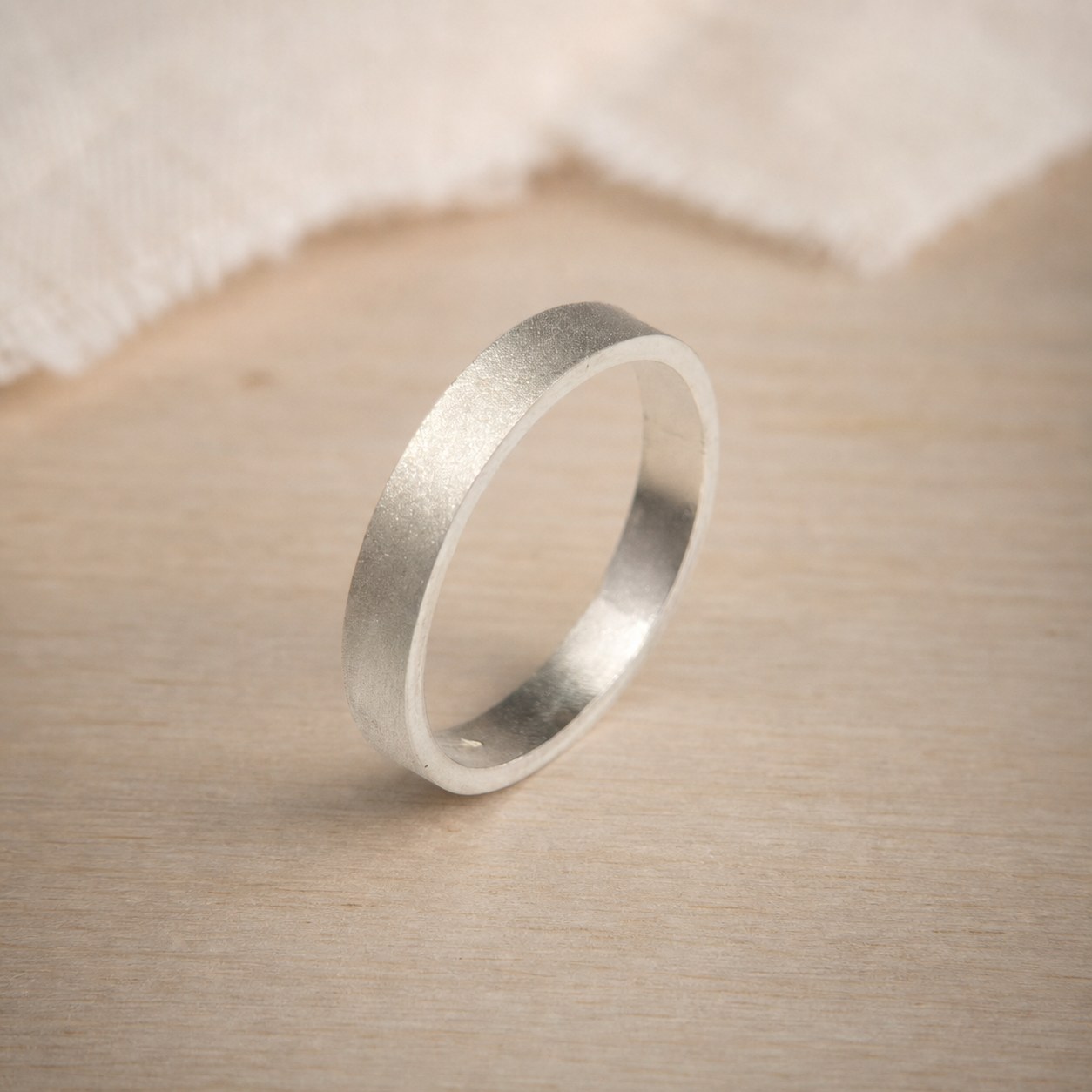 Satin Weight fine silver band during hand-finishing in the workshop